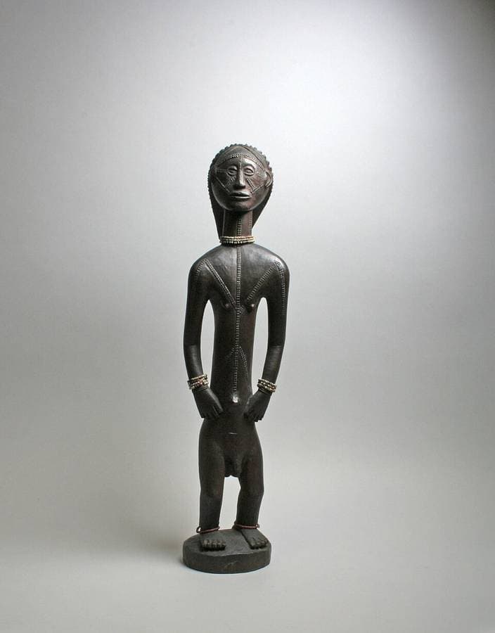 Figure masculine tabwa en bois sculpté, le torse couvert de scarifications en chevrons.