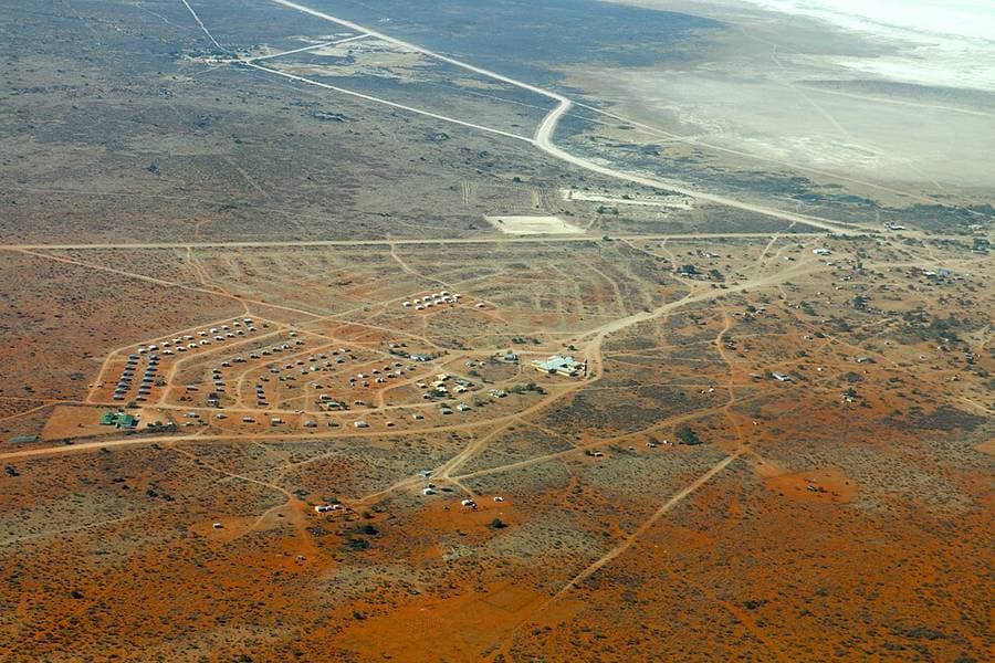 Vue aérienne d'Aminuis, bourg de maisons alignées au bord d'un pan salé, dans les terres rouges du Kalahari namibien