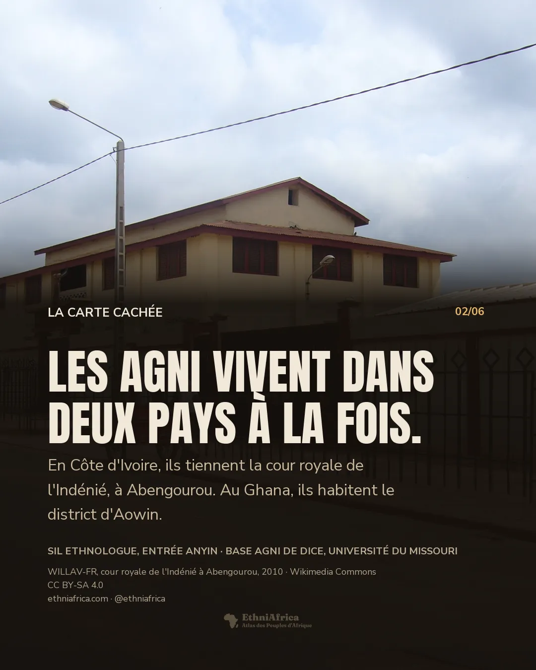 la cour royale de l'Indénié à Abengourou : un bâtiment crème à deux niveaux derrière une grille noire à médaillons, un portail gardé par deux lions peints, un homme pousse un chariot de boissons dans la rue