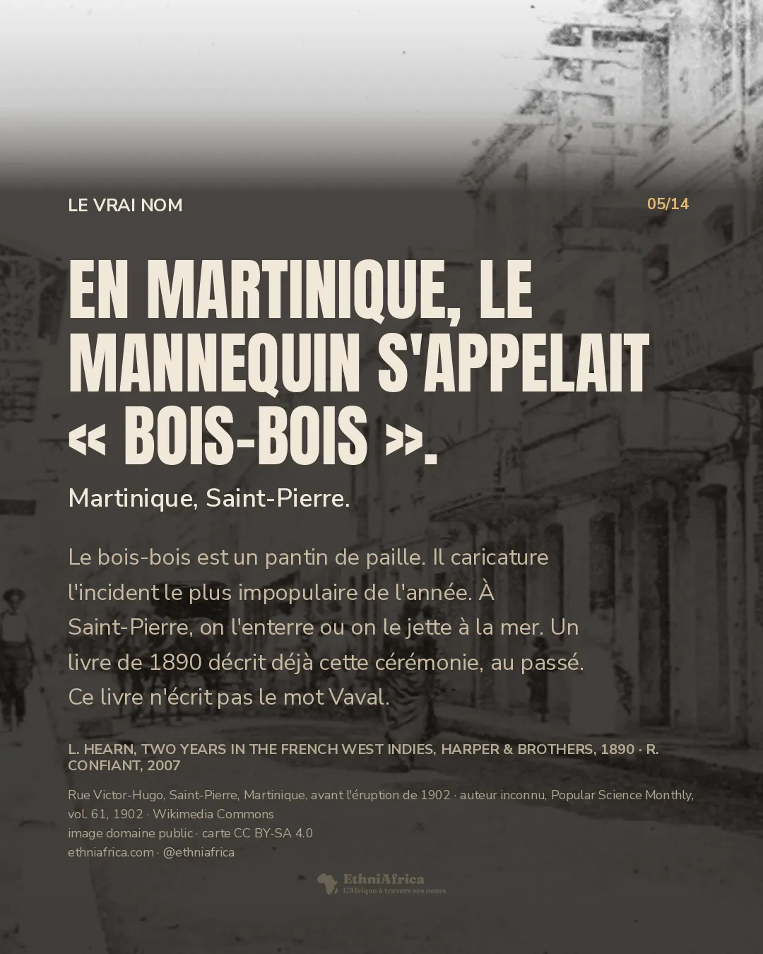 Une photographie ancienne en noir et blanc d'une rue de ville : des façades claires à balcons de fer forgé, un attelage de chevaux au milieu de la chaussée, quelques passants.