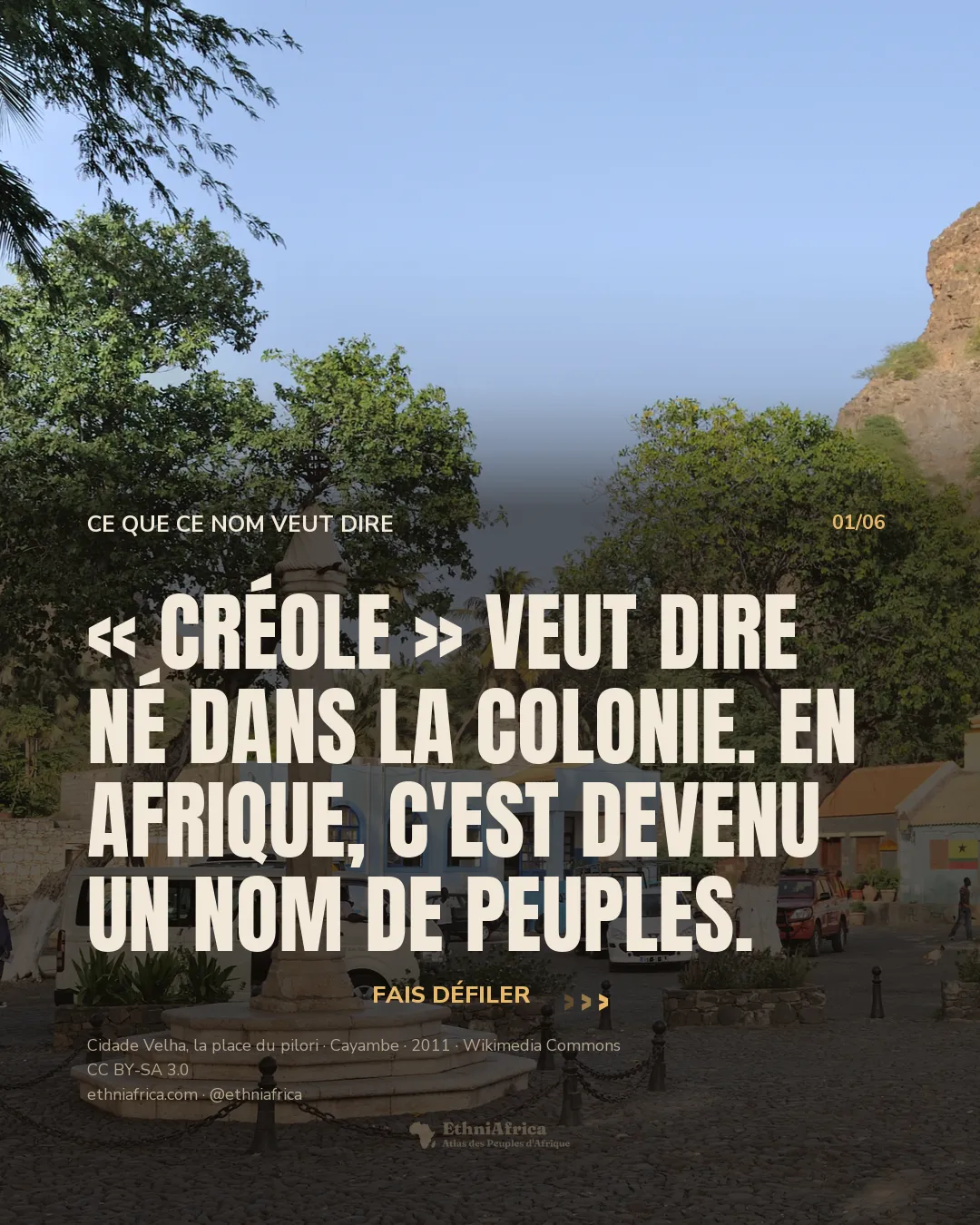 une colonne de pierre sculptée (le pilori) au centre d'une place pavée, entourée de palmiers et de maisons colorées, une colline volcanique aride en arrière-plan sous un ciel bleu