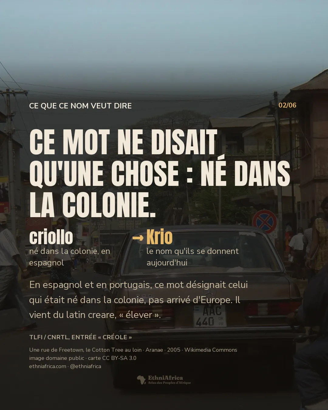 une rue animée de Freetown, une berline et une moto au premier plan, des passants de dos ou de profil sur les trottoirs, le Cotton Tree visible au loin entre les immeubles